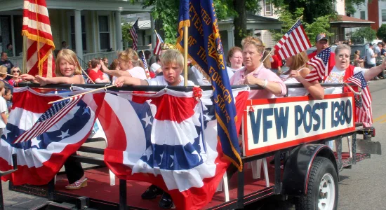 VFW Post 1380: Children and veterans waving flags from the VFW Post 1380 float